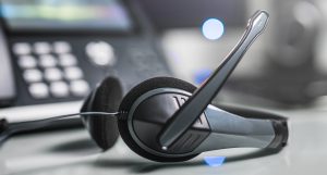 Communication support, call center and customer service help desk. VOIP headset on laptop computer keyboard.